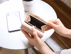 Pink floral trifold wallet showing open coin compartment and gold metal clasp closure