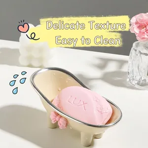 Creative bathtub-shaped soap dish with a pink bow and elegant silver trim on a white counter