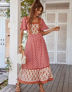 Detail of red Bohemian floral maxi dress featuring square neckline and ruffled hemline