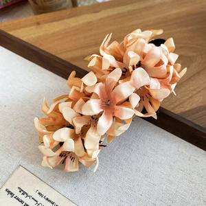 Close-up of elegant apricot fabric flower hair clip with detailed petals and silk texture