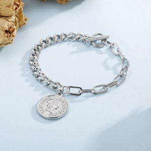 Détail d'un bracelet argenté à fermoir OT avec pendentif pièce Élisabeth sur fond bleu
