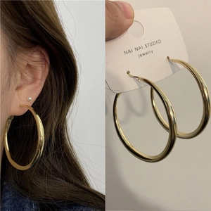 Detail view of large gold hoop earrings with zircon accents and S925 silver needles