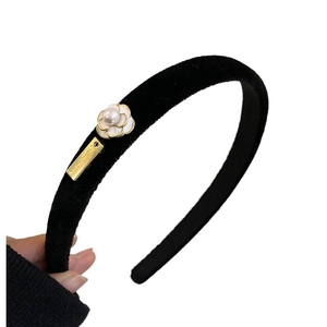Elegant black velvet headband featuring white camellia flower with pearl and gold metal tag