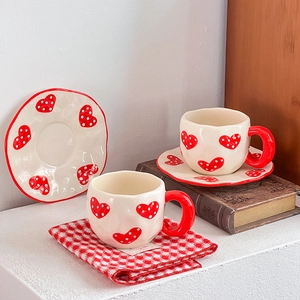 Hand-painted ceramic coffee cup and saucer set with red hearts and polka dots