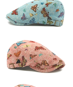 Detail showing jacquard fabric texture and colorful butterfly embroidery on beret caps