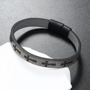 Macro detail of men's silicone cross bracelet with magnetic clasp on a white rock