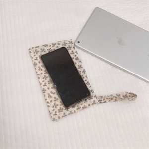 Detailed top view of a floral cotton wristlet bag showing storage capacity for a smartphone