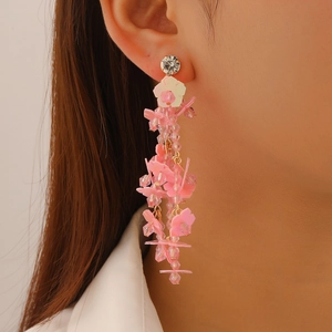 Detail of pink floral beaded tassel earrings with rhinestones on female model