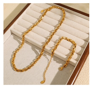 Detailed view of a gold oval link necklace and bracelet set in a jewelry box