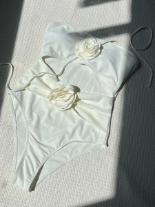 White one-piece swimsuit featuring cutout details and 3D rose floral accents