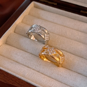 Detailed view of gold and silver hollowed rings with brushed metal and zircon stones