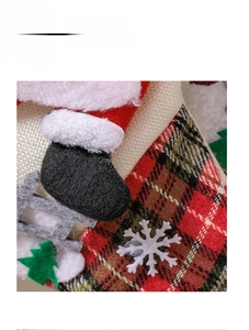 Détail de botte de Père Noël et flocon sur chaussette de Noël à carreaux rouges et verts