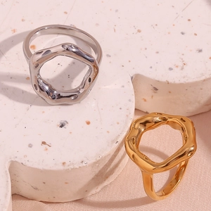 Detail of irregular wave rings in gold and silver finish on a stone display base