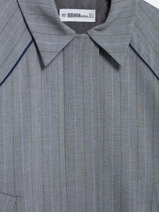 Close-up of gray striped bomber jacket lapel with navy piping and brand woven label detail