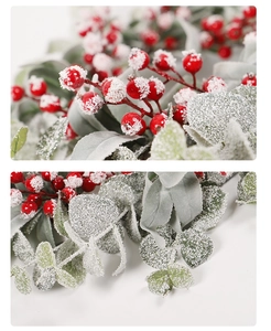 Close-up of Christmas wreath featuring red berries and frosted eucalyptus leaves
