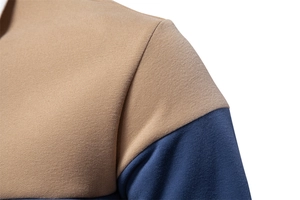 Detail of shoulder seam showing khaki and navy blue contrast stitching on cotton polo shirt