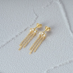 Macro shot of S925 sterling silver stamp on gold tassel earrings with white zircon