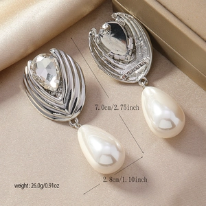 Elegant silver earrings with water drop crystals and pearls on beige silk fabric