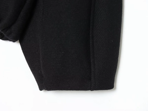 Detail shot of the black heavy fabric texture and stitching on long sleeve jacket
