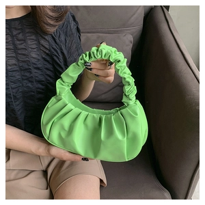 Detail view of a green pleated cloud handbag with elastic handle and soft PU leather texture