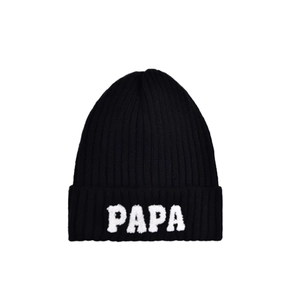 Detail of black knitted beanie featuring white PAPA embroidery on the folded cuff