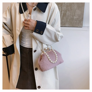 Detailed shot of pink plush kiss-lock bag with pearl handle and metal chain strap