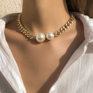 Golden chunky chain necklace with double faux pearls worn on neck for women