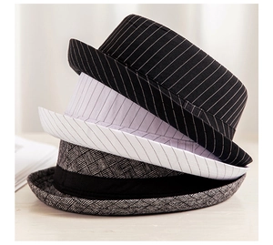 Vertical stack of jazz hats in black, white, and gray striped woven fabric textures