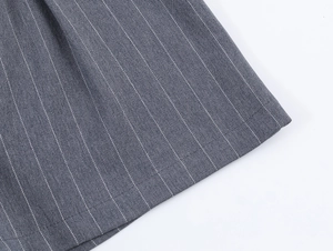 Vue macro du tissu à rayures grises montrant la texture fine et les coutures précises