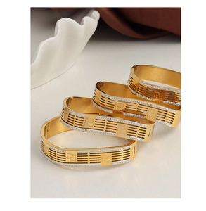 Detailed view of hollowed floral gold cuff bracelets with diamond-studded geometric edges