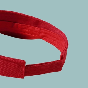 Detailed close-up of red sun visor stitching and breathable twill cotton fabric texture