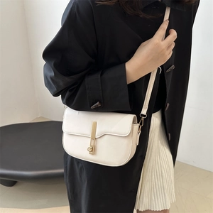 Fashionable beige saddle crossbody bag for women with gold metallic clasp and slim strap