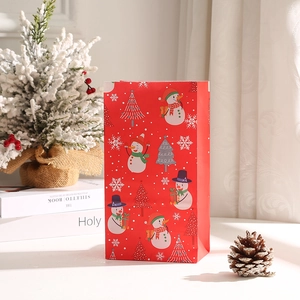 Festive red Christmas gift bag with snowman and tree prints for holiday shopping