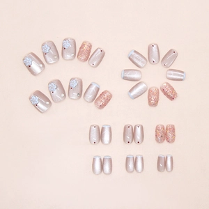 Detailed view of light blue cat eye press-on nails with 3D floral accents and glitter
