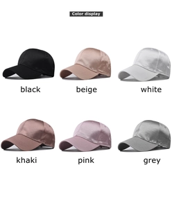 Detailed view of satin baseball caps in black, beige, white, khaki, pink, and grey