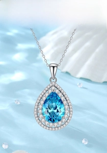 Macro shot of S925 silver necklace with pear-cut aquamarine pendant and double halo stones