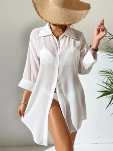 Detail of a white semi-transparent chiffon cover-up with buttons and a polo collar