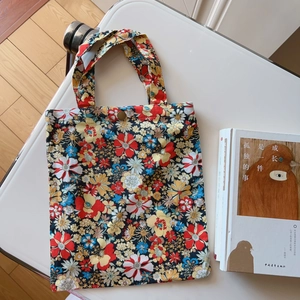 Close-up of floral pattern canvas tote bag with a secure metallic button closure