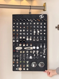 Close-up of black felt jewelry organizer hanging with earrings and sunglasses