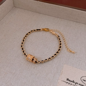 Macro detail of gold-plated cylinder pendant necklace with sparkling zircon stone inlay