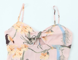 Détail d'une robe d'été à fleurs tropicales avec bretelles et noeud sur la poitrine