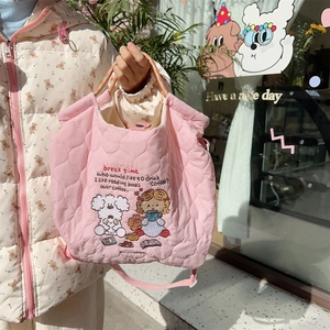 Detail of pink quilted tote bag with cute cartoon embroidery and braided rope handle