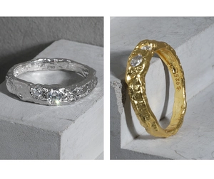 Macro shot of S925 sterling silver rings with lava texture and zircon stones on gray stone