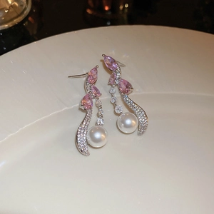 Detail of silver drop earrings with pink zircon, white crystals, and elegant pearl drop