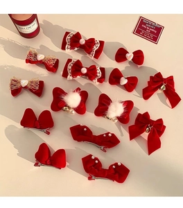 Detailed collection of 13 red velvet bow hair clips with pearls and lace on a white base