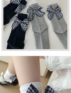 Detail view of cotton grey mid-calf socks featuring plaid bow ties and preppy style accents