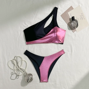 Flat lay of a sexy two-piece bikini featuring metallic pink and black color blocking fabric