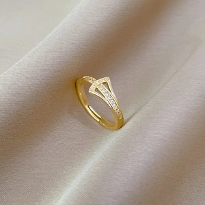 Detailed macro view of gold ginkgo leaf ring with zircon stones on champagne silk