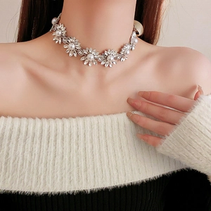 Detail of flower necklace with sparkling rhinestones and center pearls on a model