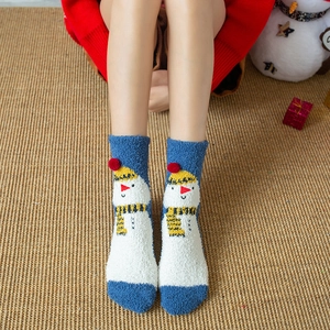 Detail of Christmas coral fleece socks with snowman embroidery and festive 3D pom-poms